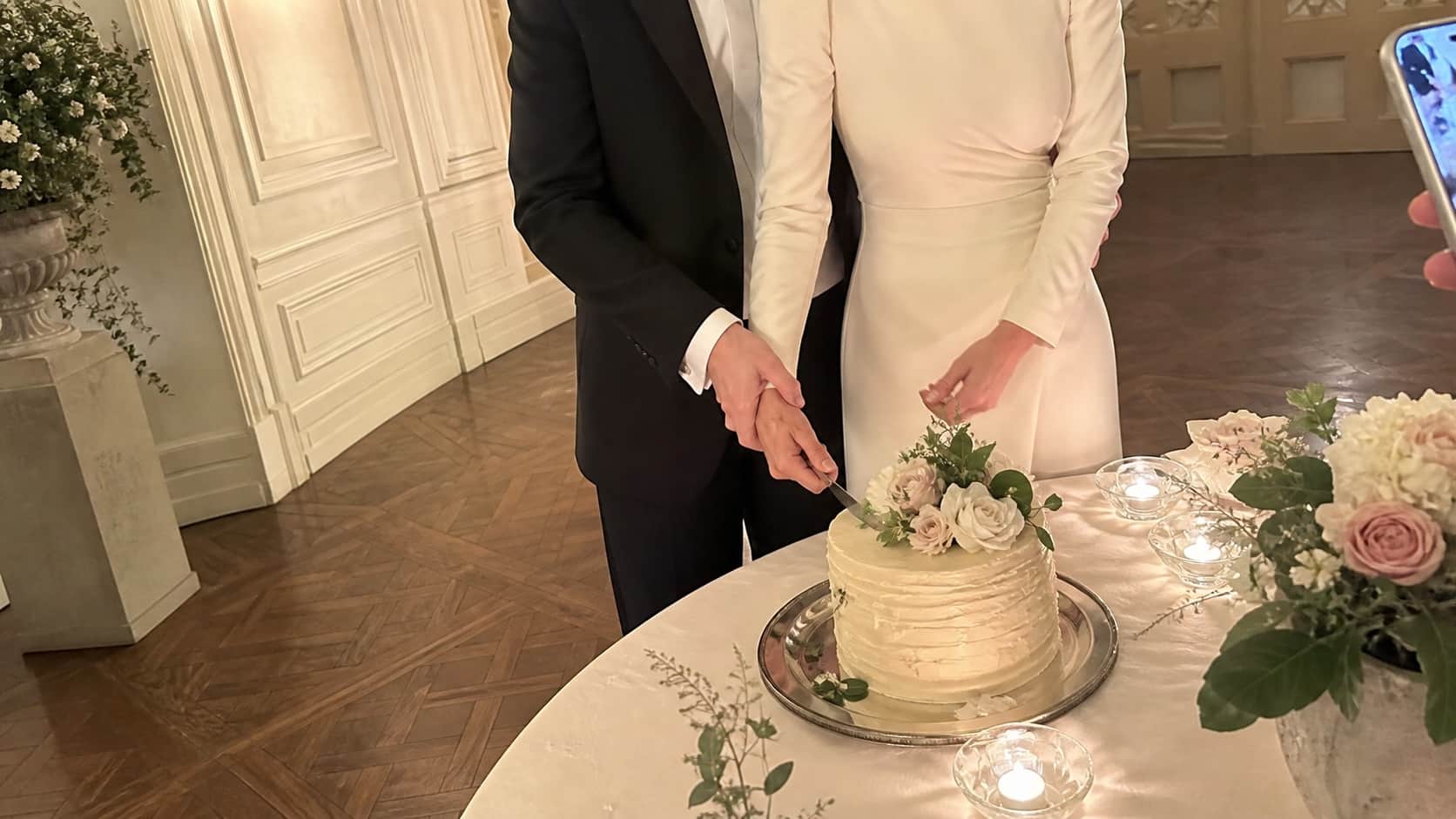 A couple cutting their wedding cake inside a private estate